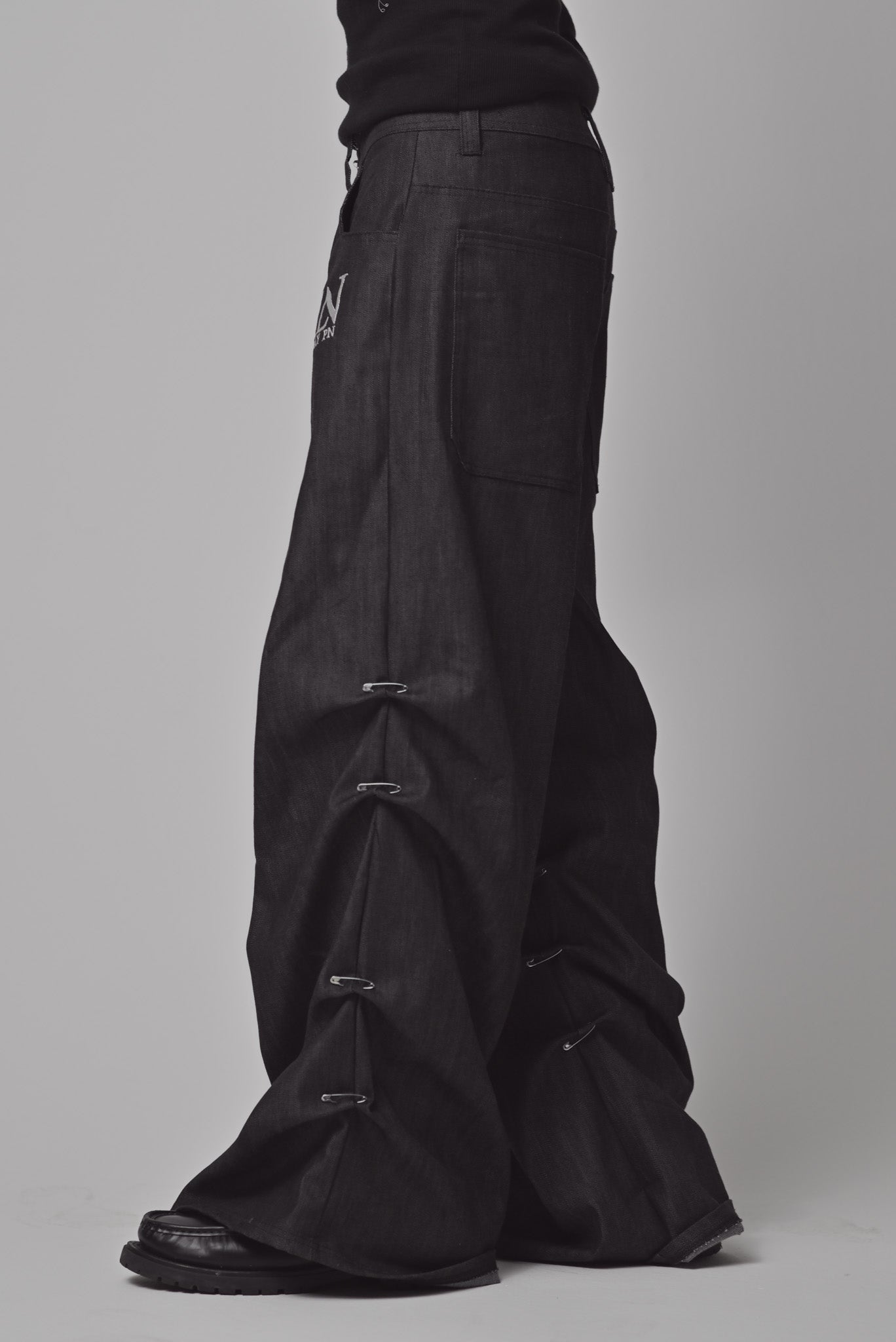 Schwarze Jeans Hose mit Sicherheitsnadeln als Details an den Seiten, von LabayPN, Ansicht von der Seite, Male Model